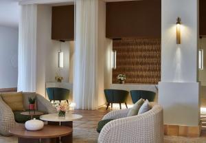 a living room with couches and tables and chairs at Conrad Chia Laguna Sardinia in Chia