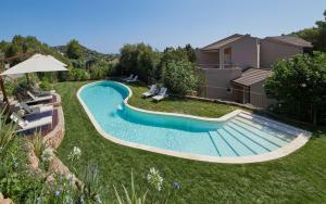 a swimming pool in a yard next to a house at Conrad Chia Laguna Sardinia in Chia
