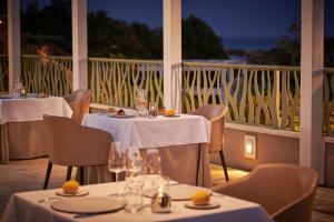 a restaurant with tables and chairs with a view of the ocean at Conrad Chia Laguna Sardinia in Chia