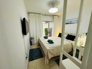 a small bedroom with a bed and a mirror at Spacious 3BR Walk to Beach & Old Town Marbella in Marbella