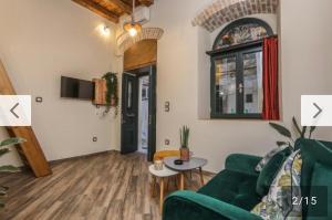 a living room with a green couch and a table at BELLA CASA del NONNO in Corfu Town