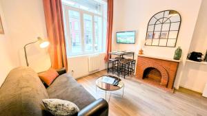 a living room with a couch and a fireplace at La Sucrerie - Charme Industriel RDC in Abbeville