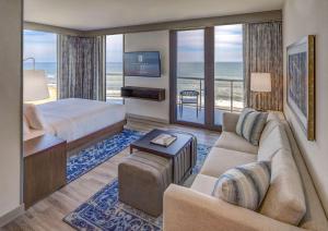弗吉尼亚海滩Embassy Suites By Hilton Virginia Beach Oceanfront Resort的一间带床和客厅的酒店房间
