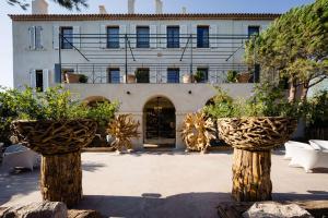 a building with two potted plants in front of it at Le Hameau Des Pesquiers Ecolodge & Spa, Curio Collection By Hilton in Hyères