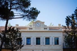 a building with a clock on the top of it at Le Hameau Des Pesquiers Ecolodge & Spa, Curio Collection By Hilton in Hyères