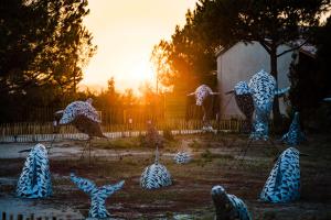 a group of statues of giraffes in a field at Le Hameau Des Pesquiers Ecolodge & Spa, Curio Collection By Hilton in Hyères