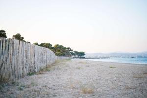 a fence on a beach next to the water at Le Hameau Des Pesquiers Ecolodge & Spa, Curio Collection By Hilton in Hyères