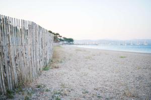 a fence on a beach next to the water at Le Hameau Des Pesquiers Ecolodge & Spa, Curio Collection By Hilton in Hyères