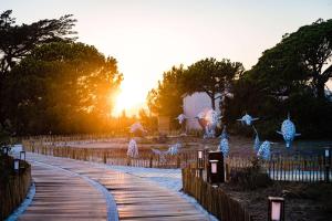 a walkway with christmas lights in a park at Le Hameau Des Pesquiers Ecolodge & Spa, Curio Collection By Hilton in Hyères