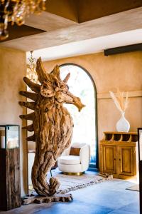 a wooden horse statue in a room with a chair at Le Hameau Des Pesquiers Ecolodge & Spa, Curio Collection By Hilton in Hyères