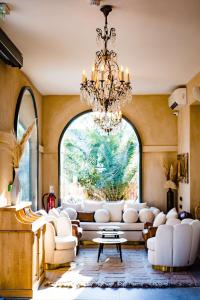 a living room with a chandelier and a large window at Le Hameau Des Pesquiers Ecolodge & Spa, Curio Collection By Hilton in Hyères