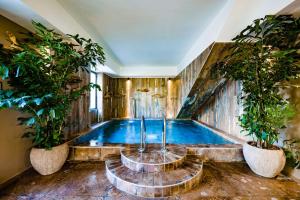 an indoor swimming pool with two potted plants at Le Hameau Des Pesquiers Ecolodge & Spa, Curio Collection By Hilton in Hyères
