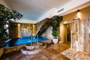 a swimming pool in a room with wooden walls at Le Hameau Des Pesquiers Ecolodge & Spa, Curio Collection By Hilton in Hyères