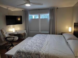 a bedroom with a bed and a desk and a television at Ranch with Cactuses in Millsboro