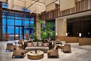 a lobby of a hotel with chairs and tables at Conrad Rabat Arzana in Rabat