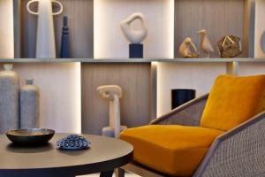 a yellow chair and a table and shelves with vases at Conrad Rabat Arzana in Rabat