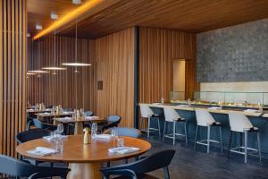 a restaurant with wooden walls and tables and chairs at Conrad Rabat Arzana in Rabat
