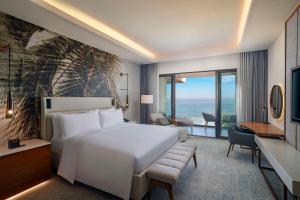 a bedroom with a large white bed and a desk at Conrad Rabat Arzana in Rabat