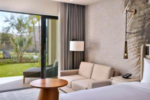 a hotel room with a bed and a couch and a table at Conrad Rabat Arzana in Rabat