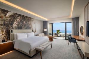 a hotel room with a bed and a view of the ocean at Conrad Rabat Arzana in Rabat