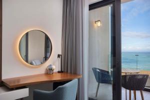 a room with a table and chairs and a mirror at Conrad Rabat Arzana in Rabat