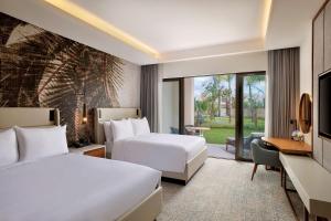 a hotel room with two beds and a desk at Conrad Rabat Arzana in Rabat +37 photos