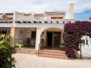 Ein weißes Haus mit einem Haufen lila Blumen. in der Unterkunft Puerta del Mar in Calpe