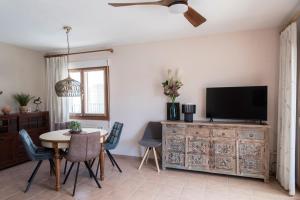 ein Wohnzimmer mit einem Tisch und einem TV auf einer Kommode in der Unterkunft Puerta del Mar in Calpe