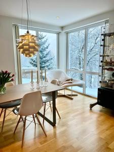 a dining room with a table and chairs and windows at Panorama Storelva in Tromsø +36 photos
