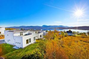 an aerial view of a white house with a lake at Panorama Storelva in Tromsø