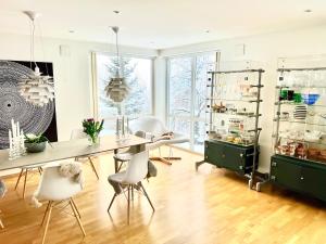 a dining room with a long table and white chairs at Panorama Storelva in Tromsø
