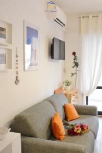 a living room with a gray couch with orange pillows at Blu Celeste - by AP Apartment in Baia Verde