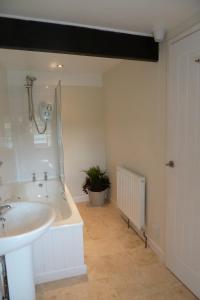 a bathroom with a sink and a bath tub at Beautiful Dartmoor cottage overlooking vineyard in Bridford