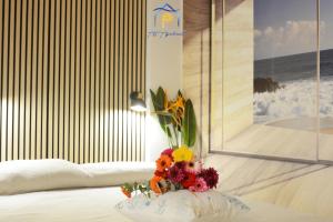 a bouquet of flowers sitting on a table in a room at Blu Celeste - by AP Apartment in Baia Verde