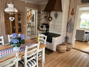 a kitchen and dining room with a table and a stove at Bagarestigen bargel punkt s e in Lysekil +10 photos