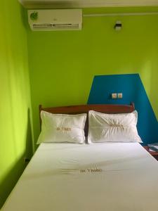 克里比Appartement Residence OR Tambo的绿色卧室配有带白色枕头的床
