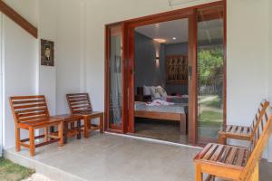 a porch with three chairs and a table and a bedroom at Casa de loren- generator and starlink in General Luna