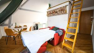 a bedroom with a bed with a ladder and a table at Le repaire du Conquérant in Dives-sur-Mer