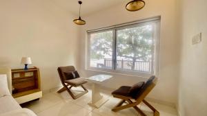 a living room with a table and chairs and a window at Willo stays beach cottage in Kannur