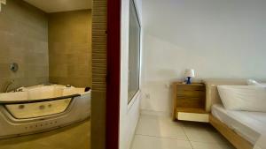 a bathroom with a bath tub next to a bed at Willo stays beach cottage in Kannur +42 photos
