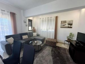 a living room with a blue couch and a tv at Papas House 3 near Faliraki Kalithies in Kalithies