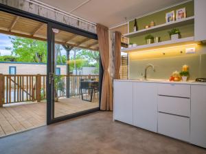 a kitchen with a sliding glass door leading to a deck at Club del Sole Stella del Mare Family Collection in Castiglione della Pescaia