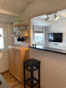 a kitchen with a counter and a stool in a room at Stuga Skrea strand in Falkenberg