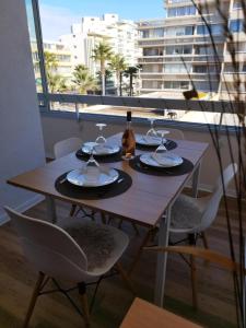 stół z butelką wina i 2 krzesłami w obiekcie Les Palmiers Appartement 4 personnes 50m De La Plage Parking w mieście Canet-en-Roussillon