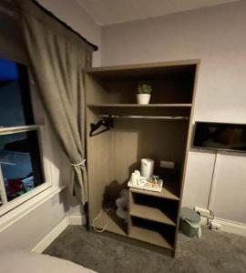 a book shelf in a bedroom with a window at OYO The Castlegate Arms in Penrith