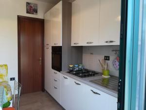 a kitchen with white cabinets and a stove top oven at Villa Maddalena a Otranto in Otranto