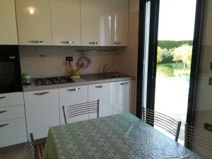a kitchen with white cabinets and a table and a window at Villa Maddalena a Otranto in Otranto +64 photos