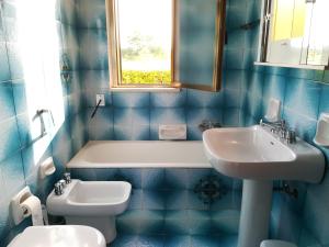 a blue tiled bathroom with a sink and a toilet at Villa Maddalena a Otranto in Otranto
