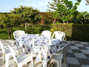 a table with white chairs and a blue and white table cloth at Villa Maddalena a Otranto in Otranto