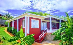 a red and white house with a red door at Maison en bord de mer in Diego Suarez